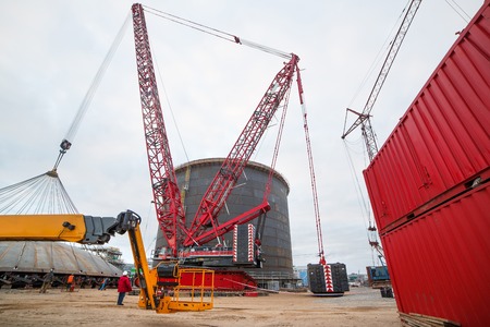 Construction of a production hall at a metallurgical plant with the help of a tower crane. Red...