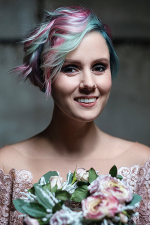 Bride model posing in pink dress with short pink and green hair, smoke, steam, concrete wall, light and shadow, sorceress, magic.の写真素材