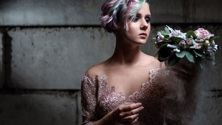 Bride model posing in pink dress with short pink and green hair, smoke, steam, concrete wall, light...