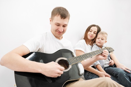 Young family, man woman and child son in new apartments. Boxes with cargo on a white background. The concept of moving to a new home.の写真素材