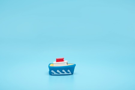 Toy rubber boat ship on a blue background. Close-up, save space, the concept of sea travel.の写真素材