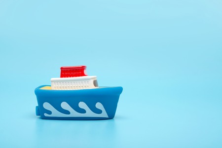 Toy rubber boat ship on a blue background. Close-up, save space, the concept of sea travel.の写真素材