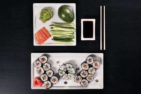 Set of rolls with red fish and ginger. Table setting. Black background. Ingredients for cooking Japanese cuisine.の写真素材