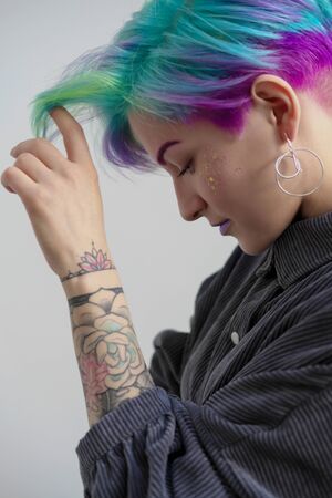 Young beautiful woman with dyed blue and green hair. Pixie bob short haircut The concept of hair styling and colored hair.の写真素材