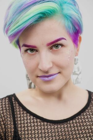 Young beautiful woman with dyed blue and green hair. Pixie bob short haircut The concept of hair...