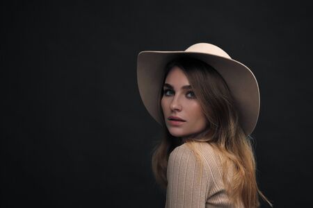 A young sensual  woman with a beautiful face and clear natural skin poses in the studio against a...