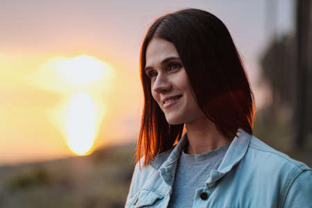Attractive young red-haired woman with a short haircut at sunset in the woods. Rest in nature.の写真素材