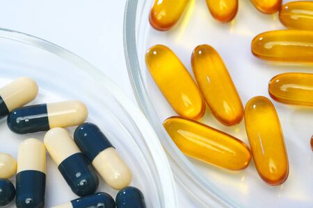 Various medical pills are on a white background. Vitamins, hemeopathy and bioactive additive against drugs.の写真素材