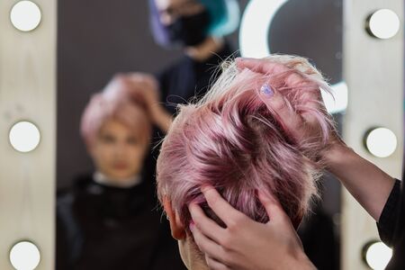 Hairdresser woman cuts her hair to a womans blonde woman. Short haircut, pixie or bob.