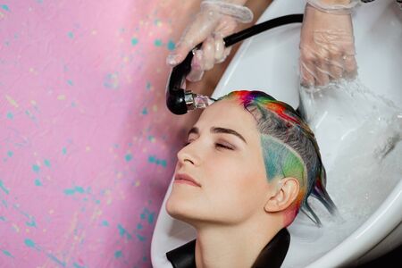 The hairdresser washes the head of a woman to a client. Colouring. The work of a colorist.の写真素材
