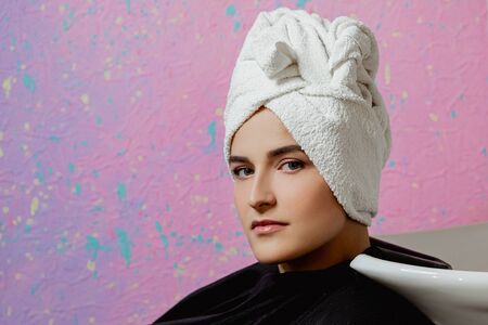 The face of a woman beauty salon customer. A white towel on head.