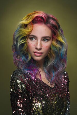 Portrait of a beautiful young girl with dyed colored hair. Hairstyle and makeup. Fashion shooting...
