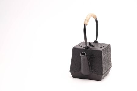 Black metal cast-iron traditional teapot on a white background.の写真素材