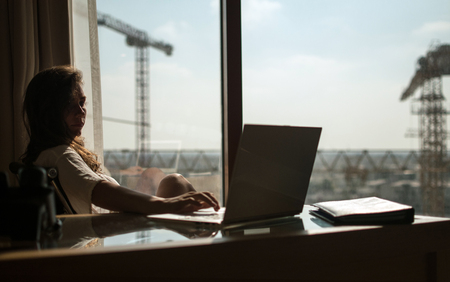 the architect , woman checks the work of the builders at his office with the help of a laptop. Female fashion designers design a product using a laptop computer with a digital tablet in a modern studio.の写真素材