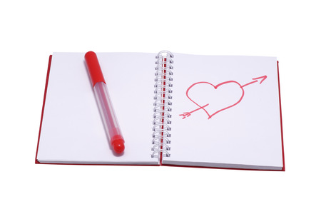 Figure heart in a notebook and a red felt-tip pen. Isolated on white.の写真素材