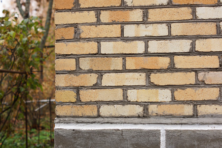 Corner of the house of yellow brick. Close-up.の写真素材