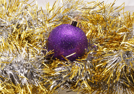 Christmas ball lying on a golden tinsel. Close-up.の写真素材