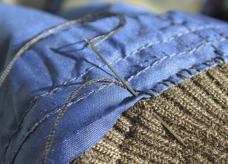 Sewing fabric needle and thread. Close-up.