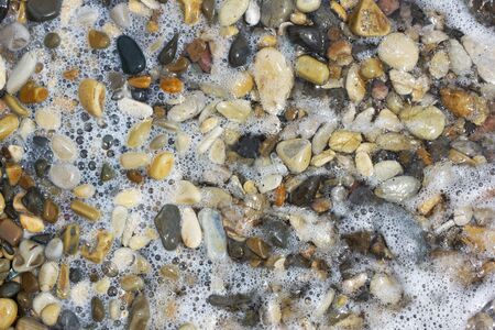   Sea pebbles and water. Close-up.                             の写真素材