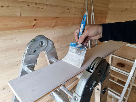 Hand paints the board with paint. Repairsの写真素材