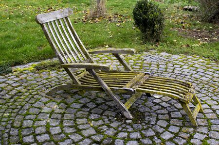 Deckchair with patina moss and lichen on a stone circleの写真素材