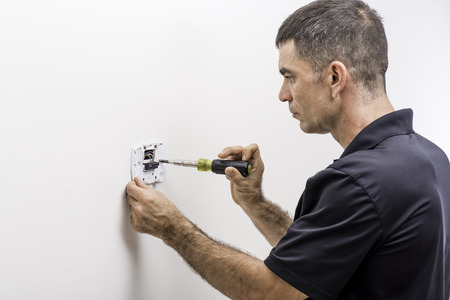 Hvac technician installing a digital thermostat