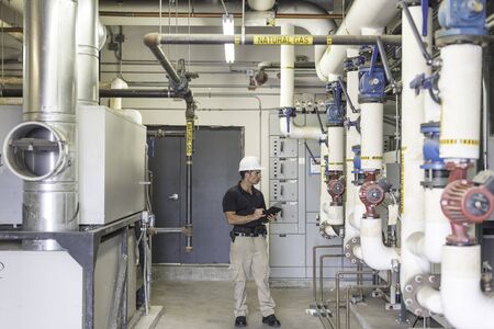 HVAC engineer doing an inspection inside of a boiler room.の写真素材