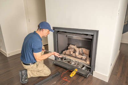 Appliance technician working under a kitchen sink installing a dishwasherの写真素材