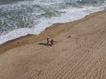 Morning at ocean Beach with footprints in sand two children are runningの写真素材