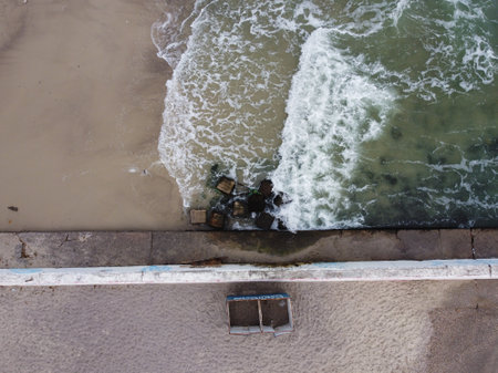 photo captures an oblong concrete pier jutting out into a blue sea Odessaの写真素材