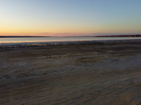 breathtaking sunset over a salt lake, with hues of orange and pink colorsの写真素材