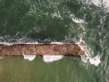 photo captures an oblong concrete pier jutting out into a blue sea Odessaの写真素材