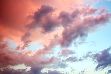 The sunset sky with clouds illuminated by bright rays of the sunの写真素材