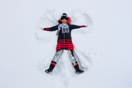 Young Girl Makes a Snow Angelの写真素材