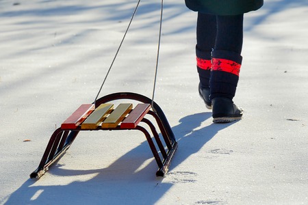 Child girl pulls sleigh broke snow snow in winterの写真素材