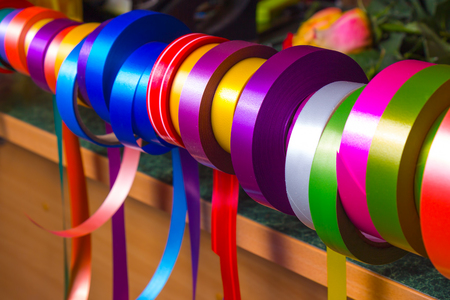 An assortment of multicolored decorative ribbons in the decor shop.の写真素材