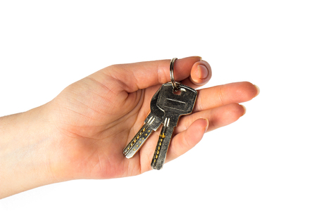 House keys in the female hand on a white backgroundの写真素材