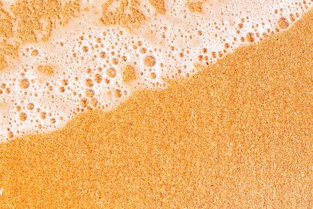 Sand and sea foam on the beach top viewの写真素材