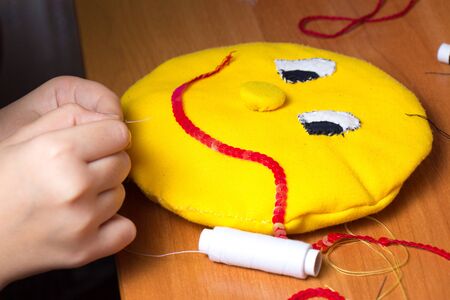 The child lives in a soft toy in the form of a yellow sunの写真素材
