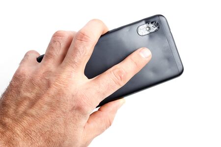 Studio closeup of a male hand, holding a smartphone with cracked screen, isolated on white background.の写真素材