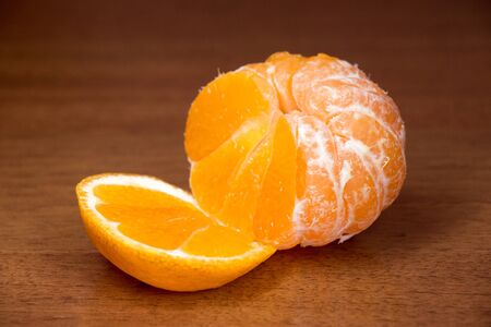 Cut tasty juicy ripe mandarin close up on a dark backgroundの写真素材