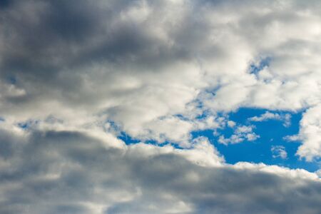 Snow-white light cumulus clouds against a blue sky