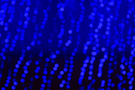 Blue Christmas bokeh against a dark backgroundの写真素材