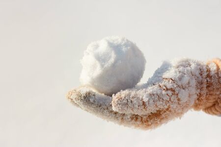 The hand of a baby girl holds snow for a game.の写真素材