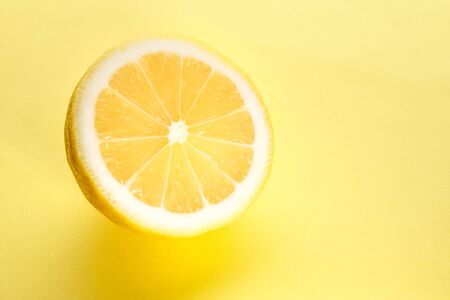 Half a lemon lies on a yellow background.の写真素材