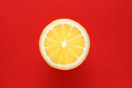 close-up shot of cut lemon on red backgroundの写真素材