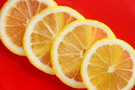Half a lemon lies on a red background.の写真素材