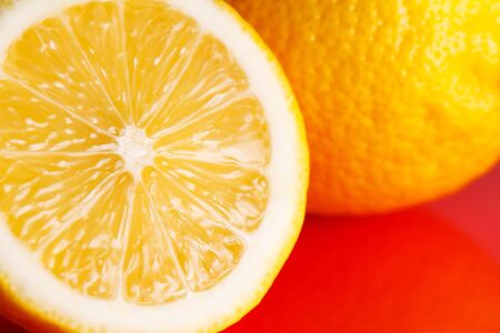 Half a lemon lies on a red background.の写真素材