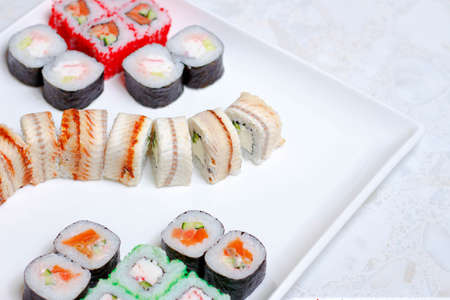 set of different types of sushi on a white plateの写真素材