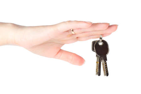 House keys in the female hand on a white backgroundの写真素材